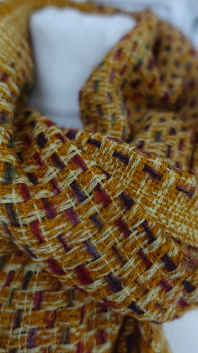 Rusty brown hands and looms woven scarf – close-up of the embellishment