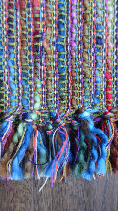 Earthy toned hands and looms woven colourful scarf – fabric and colour detail