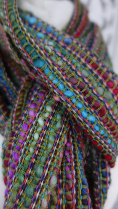 Earthy toned hands and looms woven colourful scarf – close-up of the embellishment