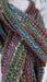 Earthy toned hands and looms woven colourful scarf – close-up of the embellishment